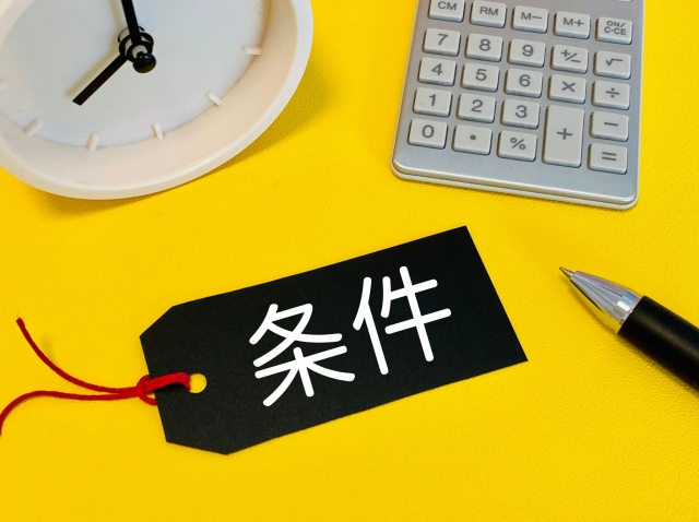 条件と書かれた黒い紙/時計/電卓/ペン