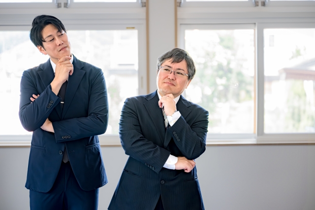 考えてるビジネスマン二人